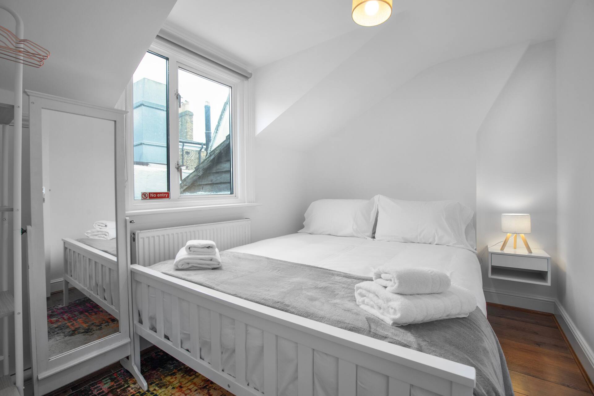 Elegant bedroom with wooden headboard and sage green throw